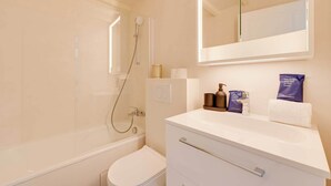 A modern bathroom with a bathtub, toilet, and vanity. - Spacious Appartement 2BR/7P - Nogent-sur-Marne (Nogent-sur-Marne)
