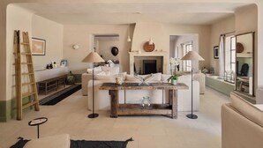 A living room with a fireplace, a coffee table, and a sofa. - Luxury Provençal house – Pool, nature & spa (Villes-sur-Auzon)