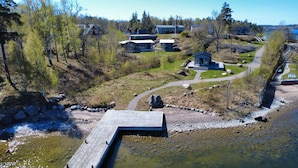 Ejendom ved søen med bådehus, pavillon og flere huse.