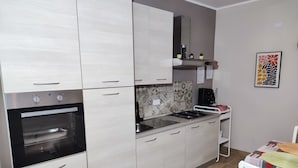 A kitchen with a built-in oven, a gas stove, and light-colored cabinets. - 50 special apartment (Pontedera)