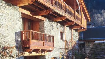 A two-story stone building with wooden balconies and a stone entrance.