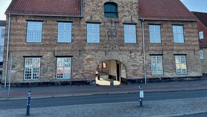 Een historisch gebouw met een symmetrische gevel, meerdere ramen en een centrale ingang.