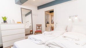 A hotel room with a bed, a dresser, a chair, and a mirror. - fewo1846 - Matrosenkoje - Centrally Located Apartment in an Older Building for 2 People on the 2nd Floor (Flensburg)