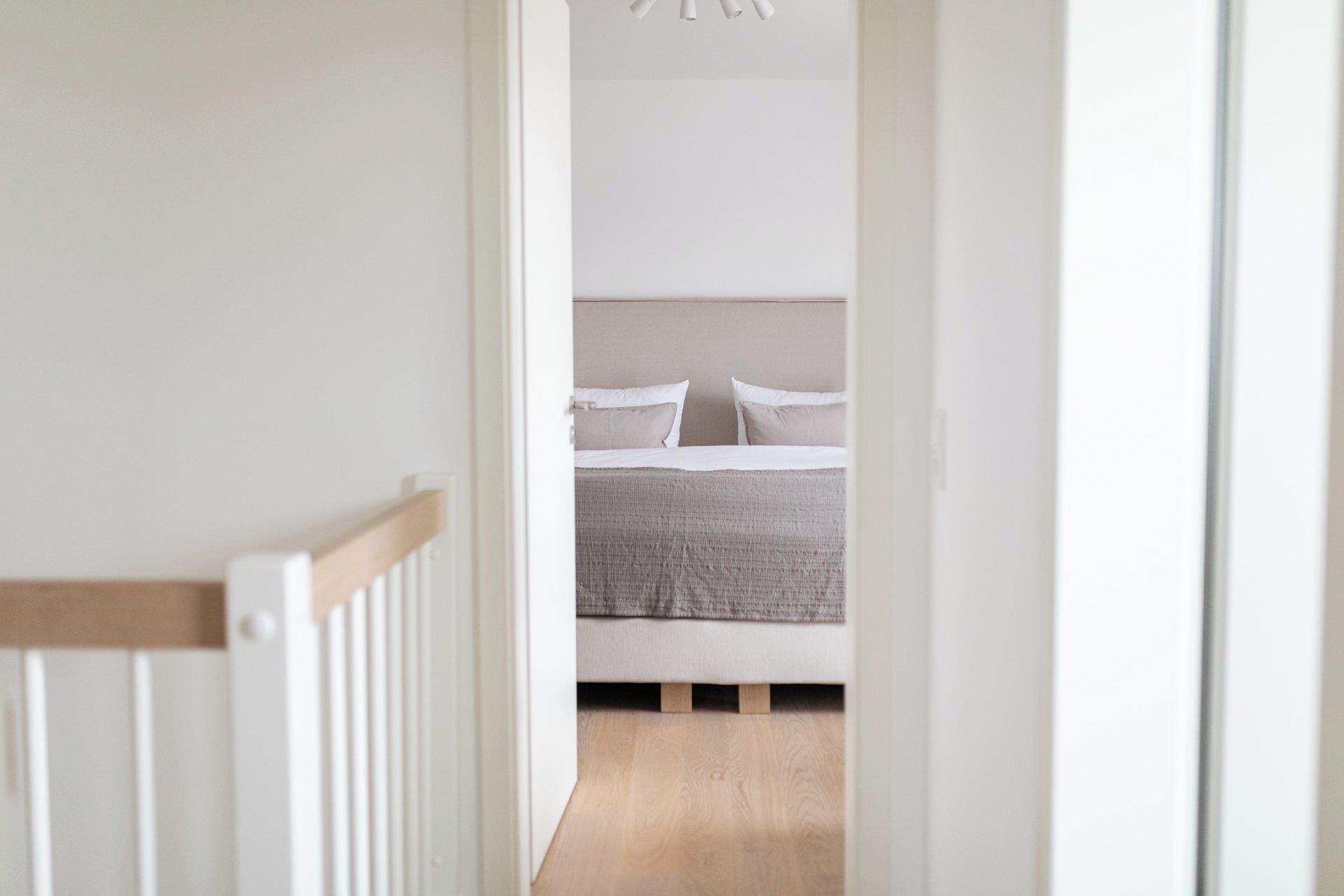 A bedroom with a bed, pillows, and a headboard.