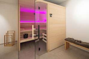 A sauna with a glass door, wooden benches, and a control panel. - // DUNE NEIGHBORHOOD NO. 2 // (Norderney)