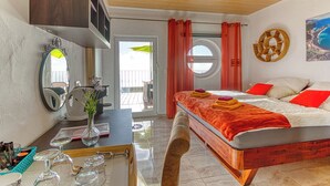 Quarto com cama, escrivaninha, espelho, janela e porta.