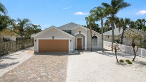 A single-story house with a garage, a front door, and a small porch. - Seabreeze- Private Pool and just steps to Beach (St. Augustine Beach)