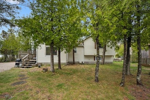 A single-story house with a front porch, a small deck, and a garage.