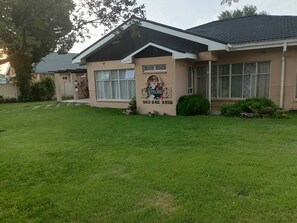 A residential house with a well-maintained lawn, a mailbox, and a number sign. - Room-charming B&B Retreat in Viljoenskro (Moqhaka)