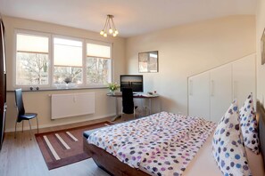 A bedroom with a bed, a desk, a chair, a radiator, and a window with blinds. - Vacation apartment near the beach in Zinnowitz with roof terrace (Zinnowitz)