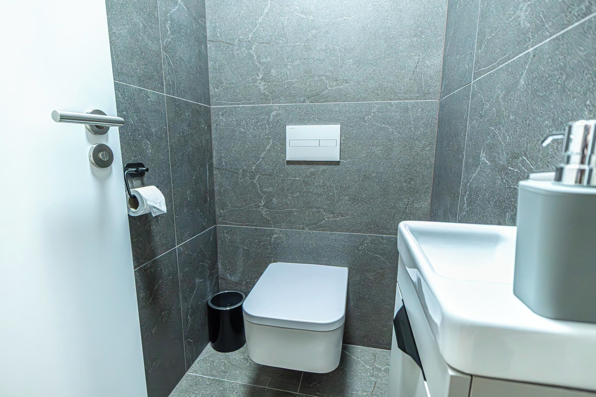 Une salle de bain moderne équipée de toilettes, d’un bidet et d’un lavabo.