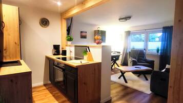 Eine moderne Küche mit Holzausstattung, einer zentralen Kochinsel und einem Essbereich mit Tisch und Stühlen.