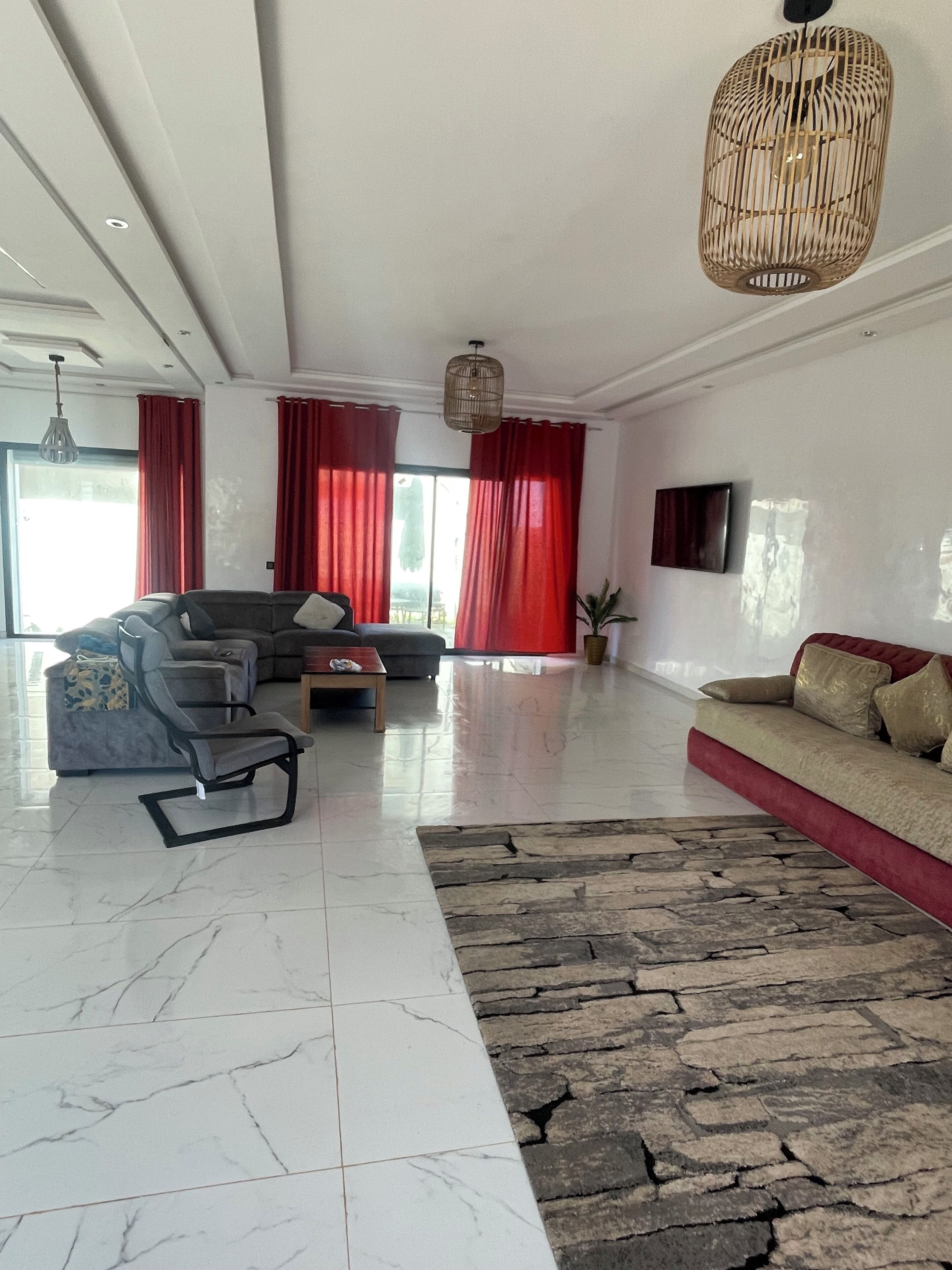 Una sala de estar amplia con sofá, una butaca, una mesita de centro y un tapete decorativo.
