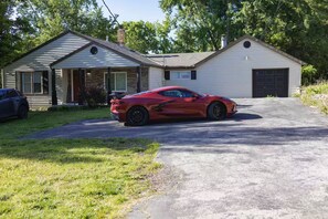 A red sports car parked in front of a two-story house with a garage. - KC World Cup-Game Day Stay-1 min to Arrowhead (Kansas City)