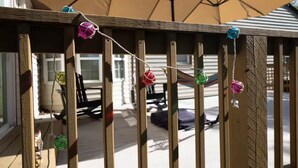 Una terraza de madera con una guirnalda de adornos coloridos.