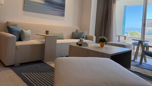 Ein modernes Wohnzimmer mit einer Couch, einem Couchtisch und Blick ins Freie.