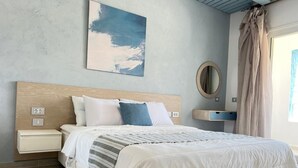 Ein Schlafzimmer mit einem Bett, Nachttischen, einem Wandspiegel und einem Gemälde.