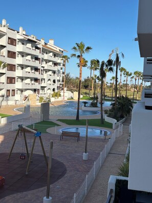 Ein Resort mit Pool, Palmen und einem Gebäude mit Balkonen.