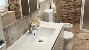 Une salle de bain avec un grand lavabo, des toilettes et une douche.