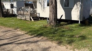 Uma fileira de casas móveis com um deck de madeira e uma pequena área externa para sentar.