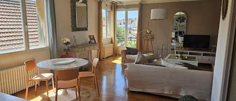 Ein gemütliches Zimmer mit Bett, Schreibtisch, Stuhl, Tisch und Fernseher.