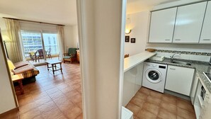 A compact apartment with a balcony, a dining area, a kitchen with a washing machine, and a small living room. - 2-bedroom apartment with parking, pool, and close to the beach in Roses (Roses)