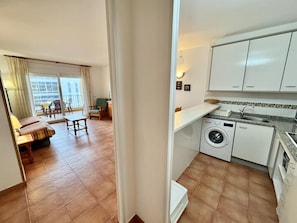 A compact apartment with a balcony, a dining area, a kitchen with a washing machine, and a small living room. - 2-bedroom apartment with parking, pool, and close to the beach in Roses (Roses)