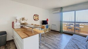 En moderne lejlighed med et køkken, spiseområde og en balkon med udsigt.