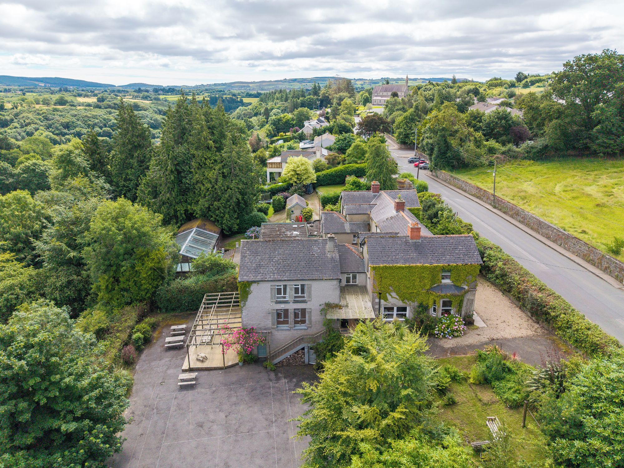 A residential area with houses, a road, and a church in the distance.
