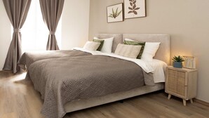 A bedroom with a bed, curtains, a bedside table with a lamp, and two wall art pieces. - One Lux Stay 3BR / 2.5ba With Kids Room at Antwerp Near Central Station (Antwerp)