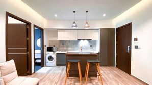 Un apartamento moderno con sala de estar, kitchenette y lavadora.