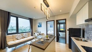 Una habitación de hotel moderna con sofá, escritorio y kitchenette.