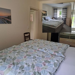 Ein Zimmer mit einem Bett, einem Sessel, einer Tür und einem Bild an der Wand.
