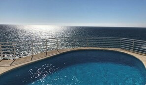 A pool with a metal railing and a view of the ocean. - San José, first line sea view - sea front (San José)