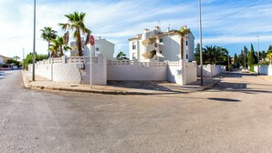 A residential area with white buildings, palm trees, and a clear sky. - Modern apartment, Montgó views, pool & private parking near Dénia centre & beach (Dénia)