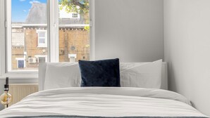 Une chambre à coucher avec un lit, une fenêtre et un radiateur.