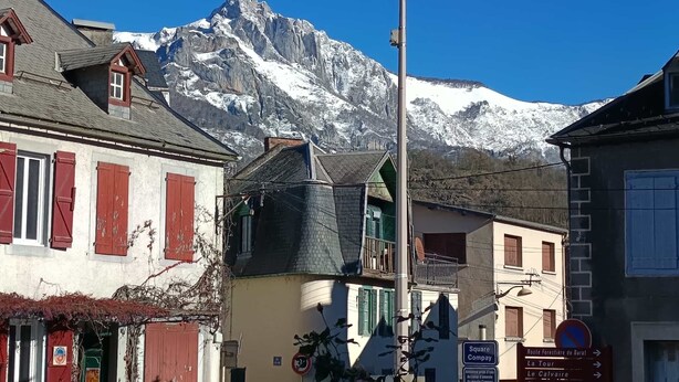 Calle con edificios y una montaña al fondo.