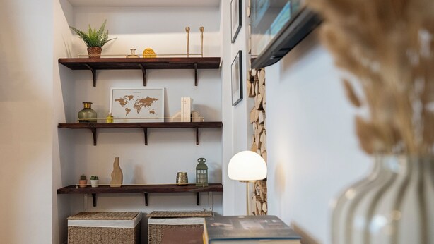 A corner with wooden shelves, a globe, books, a lamp, and a vase. - Normandy Cottage City Center charming apartment (Évreux)