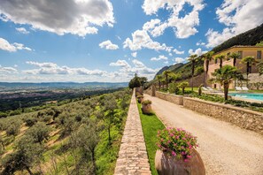 A pathway leading to a building with a pool, surrounded by greenery and a view of distant hills. - Spectacular 18th-century Mansion with pool (Terni)