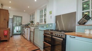 A kitchen with a stove, oven, and washing machine. - Amazing 4bedroom dog/family friendly lodge with hottub/fire bowl in Cornish wood (Bodmin)