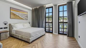 A bedroom with a bed, a bench, a painting, and a view through a window.