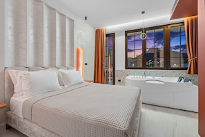 Un dormitorio moderno con una cama grande, una bañera y vistas a la ciudad desde la ventana.