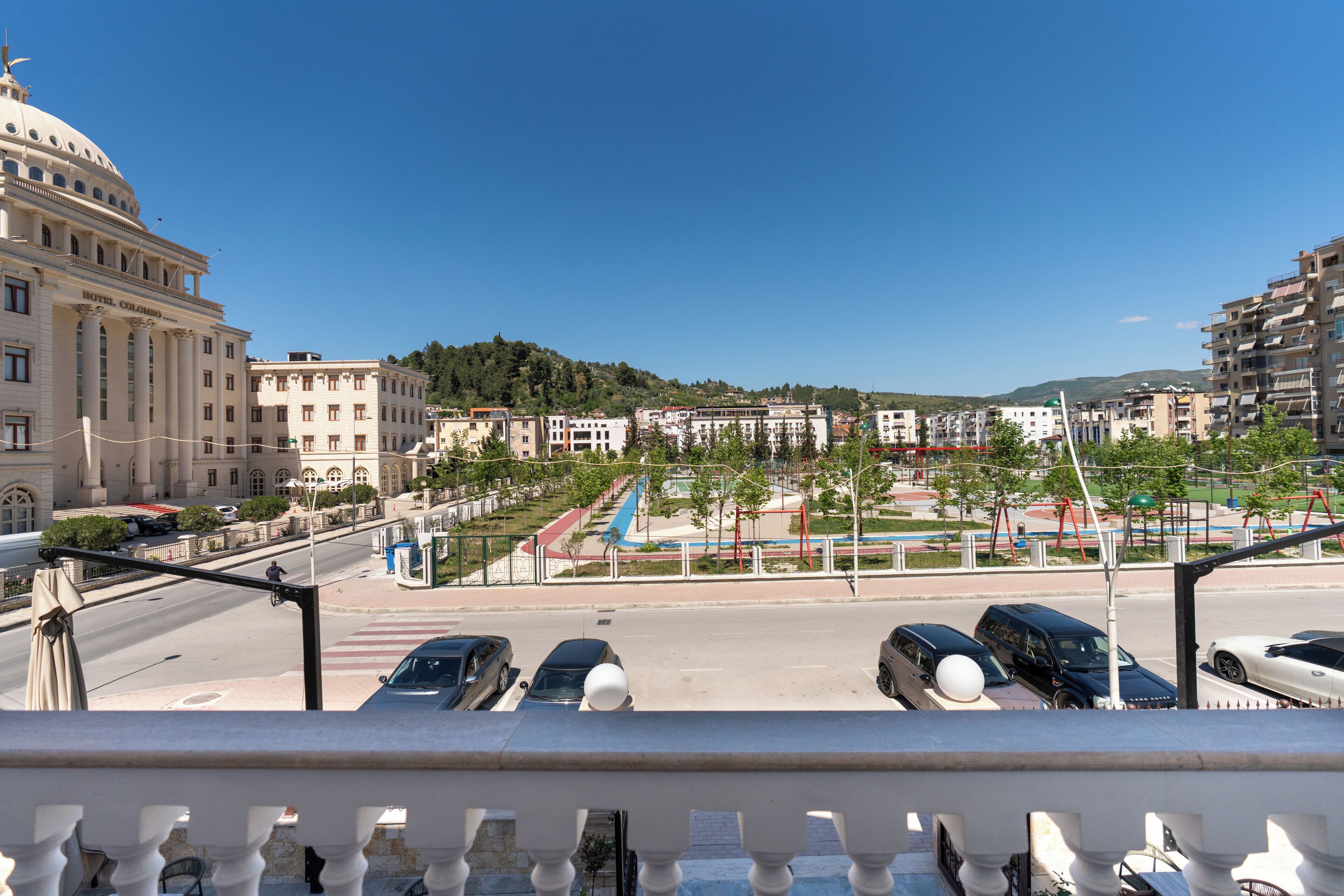 A hotel with a large dome, a central plaza with a fountain, and a view of the surrounding cityscape.