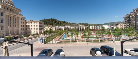 A hotel with a large dome, a central plaza with a fountain, and a view of the surrounding cityscape.