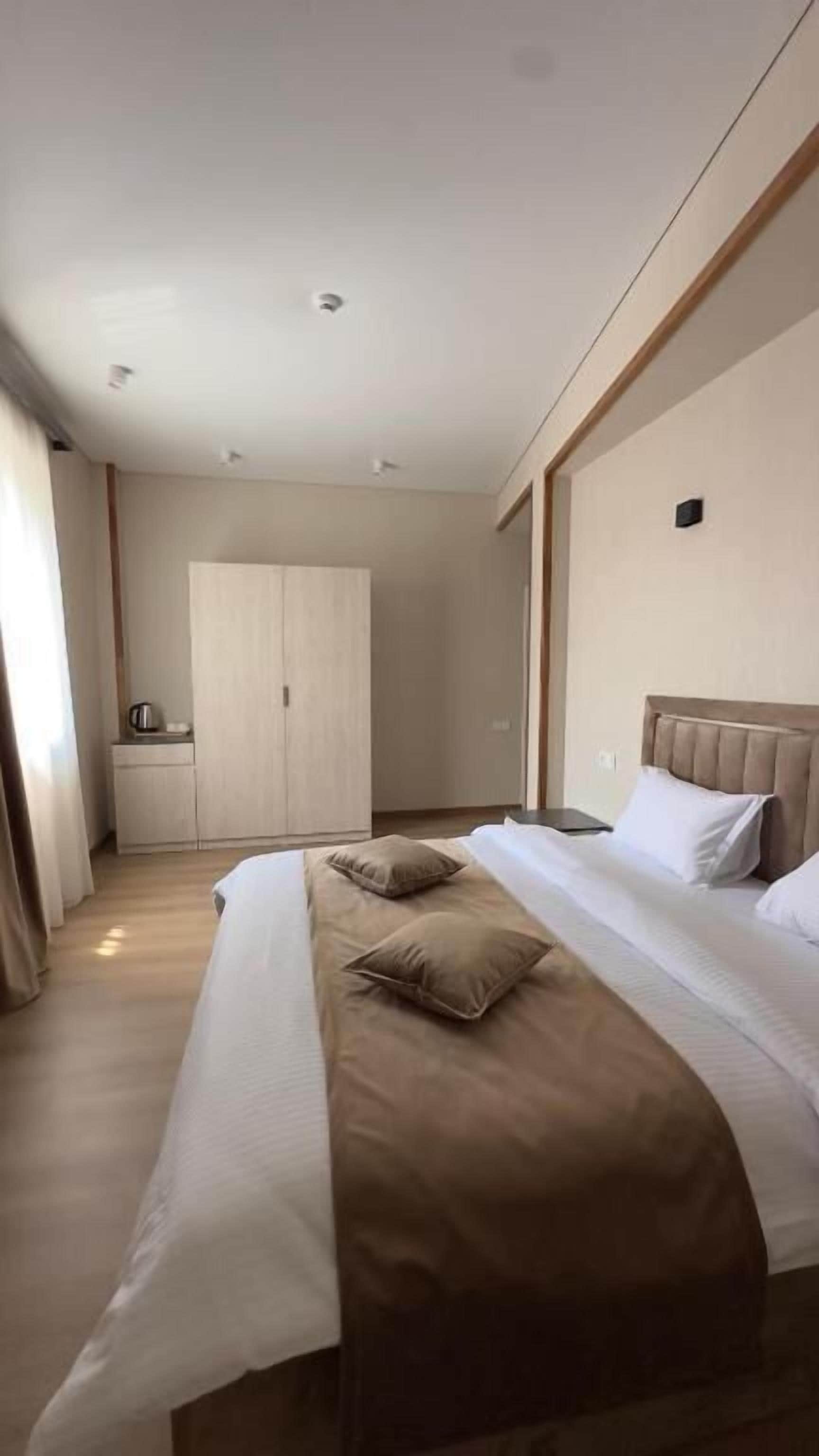 Una habitación de hotel con cama, armario y kitchenette.