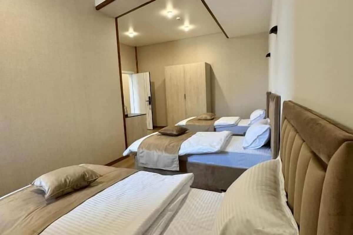 Camera d'albergo con due letti, soffitto in legno e uno specchio.