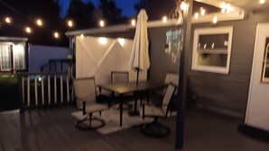 An outdoor patio with a table and chairs, a covered area, and string lights. - Serene 2-bedroom bed & breakfast in charming Saugerties (Saugerties)