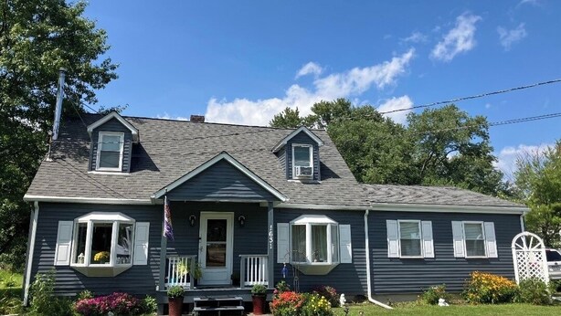 A two-story house with a front porch, a flag, and a mailbox. - Serene 2-bedroom bed & breakfast in charming Saugerties (Saugerties)