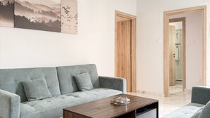 Una sala de estar moderna con un sofá gris, una mesa de centro de madera y un cuadro en la pared.