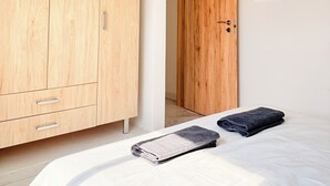 Un dormitorio con una cama, un armario de madera y una puerta.